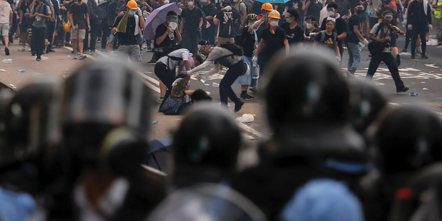 Protesters help a fallen person after clashing with riot police during a massive demonstration outside the Legislative Council in Hong Kong, Wednesday, June 12, 2019. Hong Kong police fired tear gas and rubber bullets at protesters who had massed outside government headquarters Wednesday in opposition to a proposed extradition bill that has become a lightning rod for concerns over greater Chinese control and erosion of civil liberties in the territory. (AP Photo/Kin Cheung)