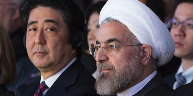 FILE - In this Jan. 22, 2014 file photo, Japanese Prime Minister Shinzo Abe, left, and Iranian President Hassan Rouhani, attend a session of the World Economic Forum in Davos, Switzerland. Abe's trip to Tehran on Wednesday, June 12, 2019, represents the highest-level effort yet to de-escalate tensions between the U.S. and Iran. The visit comes as Iran appears poised to break the 2015 nuclear deal it struck with world powers that America earlier abandoned. (AP Photo/Michel Euler, File)