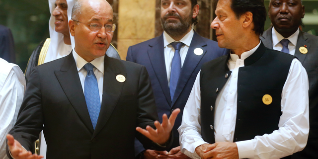 Pakistan's Prime Minister Imran Khan, right, listens to Iraq's President Barham Salih during a group picture ahead of Islamic Summit of the Organization of Islamic Cooperation (OIC) in Mecca, Saudi Arabia, early Saturday, June 1, 2019. Muslim leaders from some 57 nations gathered in Islam's holiest city of Mecca late Friday to discuss a breadth of critical issues ranging from a spike in tensions in the Persian Gulf, to Palestinian statehood, the plight of Rohingya refugees and the growing threat of Islamophobia. (AP Photo/Amr Nabil)