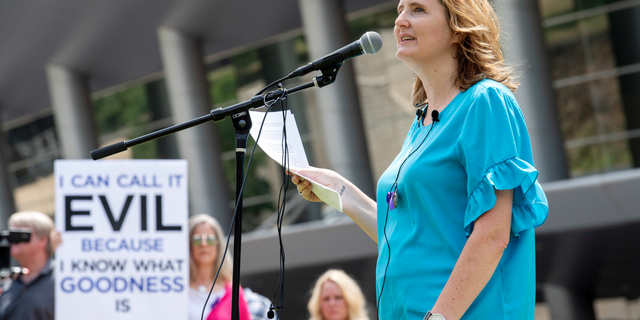 FILE - In this Tuesday, June 12, 2018 file photo, rape survivor and abuse victim advocate Mary DeMuth speaks during a rally protesting the Southern Baptist Convention's treatment of women outside the convention's annual meeting at the Kay Bailey Hutchison Convention Center in Dallas. On Tuesday, June 11, 2019, the Southern Baptist Convention gathers for its annual national meeting with one sobering topic _ sex abuse by clergy and staff _ overshadowing all others. (AP Photo/Jeffrey McWhorter)