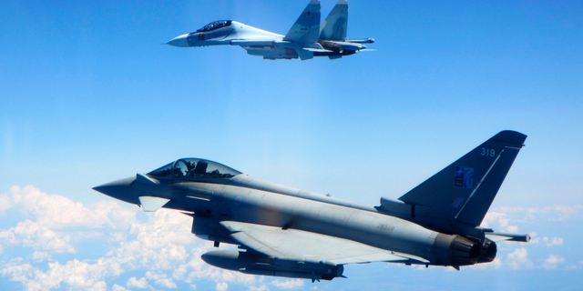 CAPTION CORRECTS AIRCRAFT NAME - In this photo taken on Saturday, June 15, 2019, a Royal Air Force Typhoon jet, bottom, flies by a Su-30 Flanker fighter. Two Royal Air Force jets deployed in Estonia have been scrambled twice in recent days, bringing the number of intercepts of Russian aircraft to eight since taking over the Baltic Air Policing mission in early May. The Typhoon jets were alerted Friday to intercept a Russian Su-30 Flanker fighter, and passed a military transport craft as it was escorting the fighter over the Baltic Sea. In a second incident on Saturday, RAF crews intercepted a Su-30 Flanker fighter and an Ilyushin Il-76 Candid transport aircraft that was traveling north from the Russian enclave of Kaliningrad toward Estonian and Finnish airspace. (UK Ministry of Defence via AP)