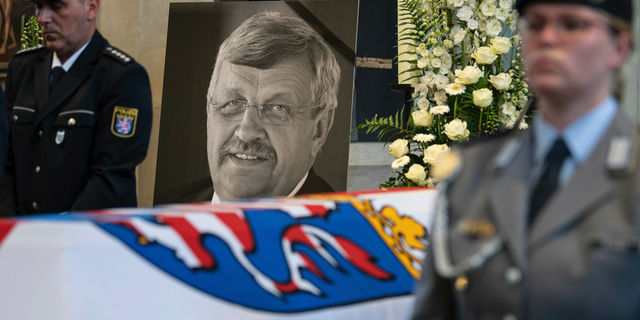 FILE-In this June 13, 2019 file photo a picture of Walter Luebcke stands behind his coffin during the funeral service in Kassel, Germany. German authorities say they have arrested a 45-year-old man in connection with their investigation into the slaying of a regional official from Chancellor Angela Merkel’s party. (Swen Pfoertner/dpa via AP)