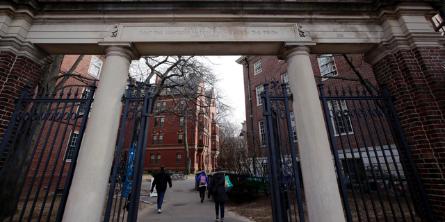 In this Dec. 13, 2018, file photo, a gate opens to the Harvard University campus in Cambridge, Mass.