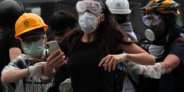 Protesters flee after police fired tear gas during a massive demonstration outside the Legislative Council in Hong Kong on June 12, 2019. (AP Photo/Kin Cheung)