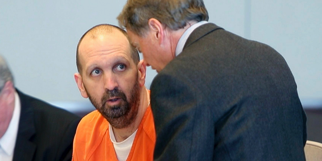 FILE - In this March 14, 2017, file photo, Craig Hicks, center, charged with the murder of three Muslim students in Chapel Hill, N.C., listens to with attorney Steve Freedman as he makes an appearance in a Durham County courtroom in Durham, N.C. Hicks is expected Wednesday, June 12, 2019, to enter a plea in court in Durham, more than four years after the slayings, which the victims’ families blamed on bigotry. (Chris Seward/The News & Observer via AP, FIle)