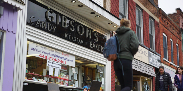FILE - In this Nov. 22, 2017 file photo, pedestrians pass the storefront of Gibson's Bakery in Oberlin, Ohio. On Thursday, June 13, 2019, a jury awarded the owners of the bakery $33 million in punitive damages in its lawsuit against Oberlin College. The same jury awarded David Gibson and son, Allyn, $11 million in compensatory damages last week. The market owners claimed student protests ruined their business. (AP Photo/Dake Kang, File)