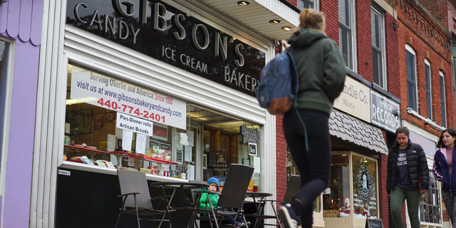 FILE - In this Nov. 22, 2017 file photo, pedestrians pass the storefront of Gibson's Bakery in Oberlin, Ohio. On Thursday, June 13, 2019, a jury awarded the owners of the bakery $33 million in punitive damages in its lawsuit against Oberlin College. The same jury awarded David Gibson and son, Allyn, $11 million in compensatory damages last week. The market owners claimed student protests ruined their business. (AP Photo/Dake Kang, File)
