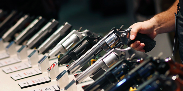 Handguns are displayed at the Smith &amp; Wesson booth at the Shooting, Hunting and Outdoor Trade Show in Las Vegas. (AP Photo/John Locher, File)