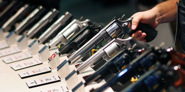 FILE - In this Jan. 19, 2016 file photo, handguns are displayed at the Smith & Wesson booth at the Shooting, Hunting and Outdoor Trade Show in Las Vegas. Two former trade show workers have pleaded guilty to federal firearms charges following the theft of weapons from the U.S. gun industry's biggest annual convention, Thursday, June 13, 2019. (AP Photo/John Locher, File)