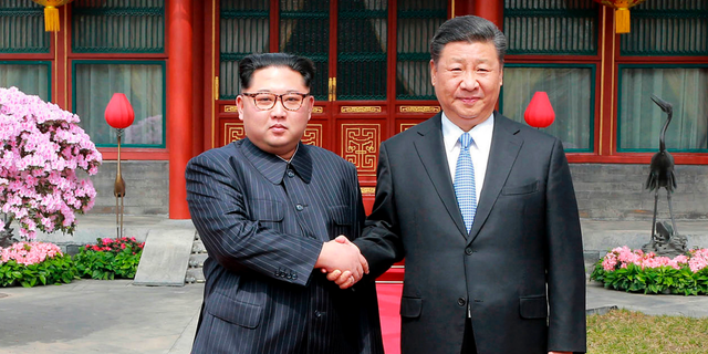 FILE - In this March 27, 2018, file photo, North Korean leader Kim Jong Un, left, shakes hands with Chinese counterpart Xi Jinping at Diaoyutai State Guesthouse in Beijing, China. Kim’s fifth meeting with Xi continues his ambitious diplomatic outreach that has included summits with the leaders of the United States, South Korea and Russia in the past year and a half. Experts say Kim is attempting to form a united front with North Korea’s main ally China to strengthen his leverage in the stalled nuclear negotiations with the United States. (Korean Central News Agency/Korea News Service via AP, File)