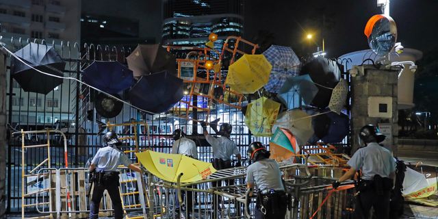 Riot police clear barricades blocked by protesters outside the police headquarters as thousands gathered to demand for an independent inquiry into a heavy-handed police crackdown at a protest earlier this month, in Hong Kong during the early hours of Thursday, June 27, 2019. Thousands of people joined Hong Kong's latest protest rally Wednesday night against legislation they fear would erode the city's freedoms, capping a daylong appeal to world leaders ahead of a G-20 summit this week that brings together the heads of China, the United States and other major nations. (AP Photo/Kin Cheung)