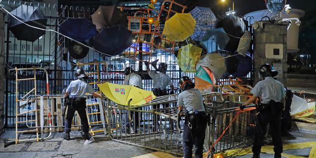 Riot police clear barricades blocked by protesters outside the police headquarters as thousands gathered to demand for an independent inquiry into a heavy-handed police crackdown at a protest earlier this month, in Hong Kong during the early hours of Thursday, June 27, 2019. Thousands of people joined Hong Kong's latest protest rally Wednesday night against legislation they fear would erode the city's freedoms, capping a daylong appeal to world leaders ahead of a G-20 summit this week that brings together the heads of China, the United States and other major nations. (AP Photo/Kin Cheung)