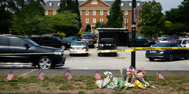 FILE - In this June 1, 2019, file photo, a makeshift memorial rests at the edge of a police cordon in front of a municipal building that was the scene of a shooting in Virginia Beach, Va. The Virginia Beach killing is one of 11 mass workplace killings dating back to 2006 in the U.S., according to a database of mass killings maintained through a partnership between AP, USA Today and Northeastern University. (AP Photo/Patrick Semansky, File)