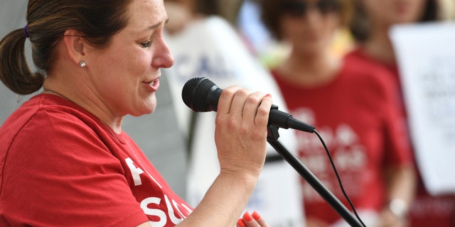 Jules Woodson, of Colorado Springs, Colo., speaks during a rally outside the Southern Baptist Convention's annual meeting Tuesday, June 11, 2019, in Birmingham, Ala. First-time attendee Woodson spoke through tears as she described being abused sexually by a Southern Baptist minister. (AP Photo/Julie Bennett)