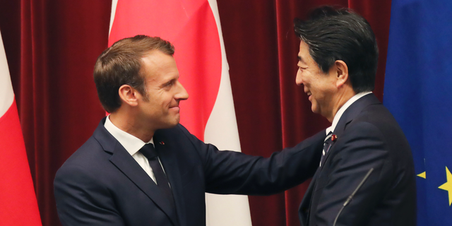 French President Emmanuel Macron, left, shakes hands with Japanese Prime Minister Shinzo Abe after their joint press conference at Abe's official residence in Tokyo, Wednesday, June 26, 2019. (AP Photo/Koji Sasahara, pool)