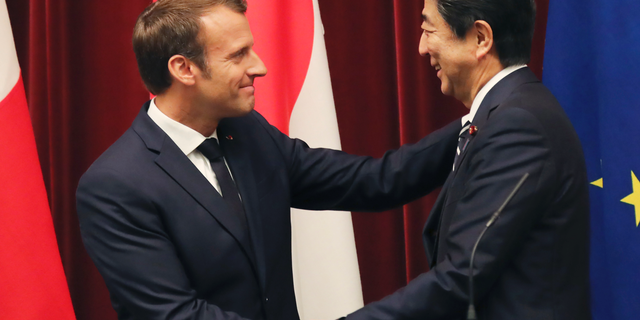 French President Emmanuel Macron, left, shakes hands with Japanese Prime Minister Shinzo Abe after their joint press conference at Abe's official residence in Tokyo, Wednesday, June 26, 2019. (AP Photo/Koji Sasahara, pool)