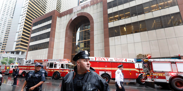New York City Police and Fire Department personnel secure the scene in front of a building in midtown Manhattan where a helicopter crash landed, Monday, June 10, 2019. The Fire Department says the helicopter crash-landed on the top of the tower, which isn't far from Rockefeller Center and Times Square. (AP Photo/Richard Drew)
