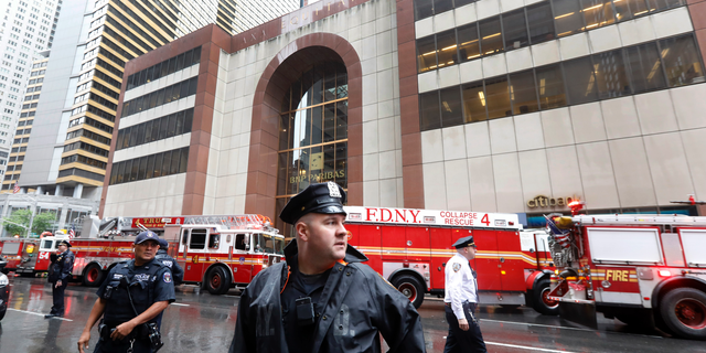 New York City Police and Fire Department personnel secure the scene in front of a building in midtown Manhattan where a helicopter crash landed, Monday, June 10, 2019. The Fire Department says the helicopter crash-landed on the top of the tower, which isn't far from Rockefeller Center and Times Square. (AP Photo/Richard Drew)