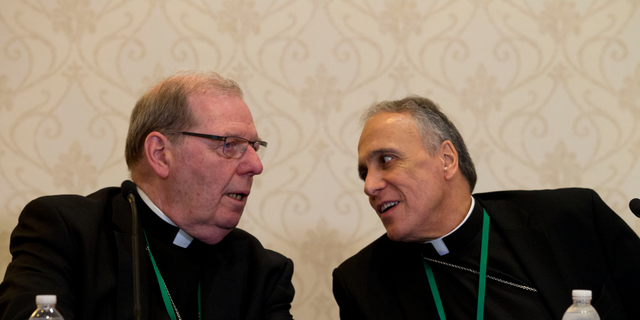 Bishop Robert Deeley of Portland Bishop of Diocese of Portland, left, speaks with Cardinal Daniel DiNardo of the Archdiocese of Galveston-Houston, speaks during a news conference at the United States Conference of Catholic Bishops (USCCB), 2019 Spring meetings in Baltimore, Md., Tuesday, Jun 11, 2019. (AP Photo/Jose Luis Magana)