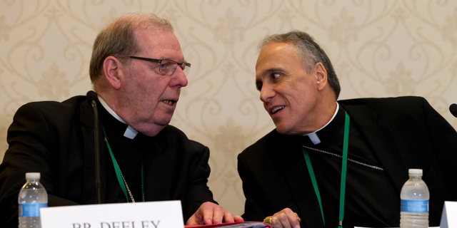 Bishop Robert Deeley of Portland Bishop of Diocese of Portland, left, speaks with Cardinal Daniel DiNardo of the Archdiocese of Galveston-Houston, speaks during a news conference at the United States Conference of Catholic Bishops (USCCB), 2019 Spring meetings in Baltimore, Md., Tuesday, Jun 11, 2019. (AP Photo/Jose Luis Magana)