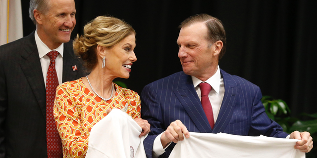 FILE - In this Sept. 20, 2018, file photo, Hugh F. Culverhouse Jr., right, and wife, Eliza show off T-shirts from the the University of Alabama law school, which now bears his name in Tuscaloosa, Ala. The University of Alabama released a selection of emails Sunday, June 9, 2019. showing its relationship soured with Culverhouse long before he called on students to boycott enrolling at the school over the state’s hardline anti-abortion legislation. (Gary Cosby Jr./The Tuscaloosa News via AP, File)