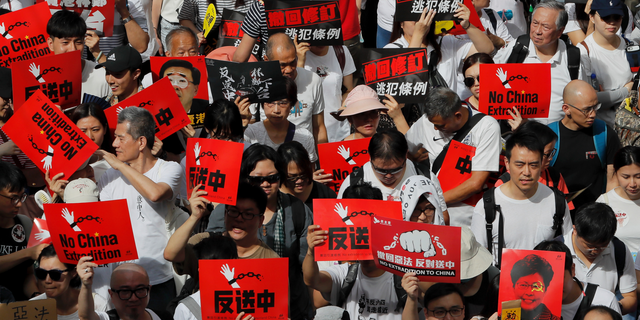 Protesters hold placards march in a rally against the proposed amendments to extradition law in Hong Kong, Sunday, June 9, 2019.  (AP Photo/Kin Cheung)