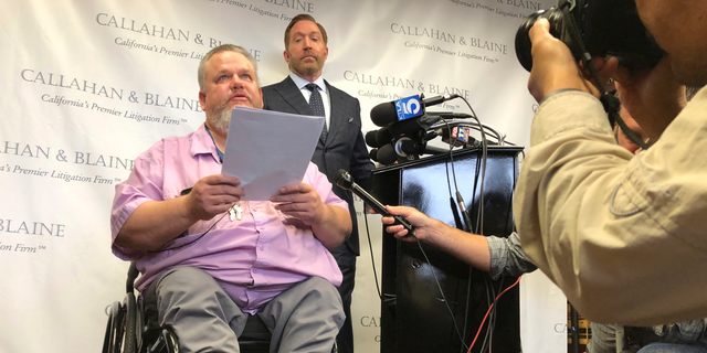Attorney Daniel J. Callahan, right, looks at his client, Geoffrey Johnson, during a news conference announcing a lawsuit filed against lawyer Michael Avenatti in Santa Ana, Calif., Thursday, June 13, 2019. Johnson says that Avenatti, his former lawyer, received a $4 million settlement check from Los Angeles County over injuries he suffered in sheriff department custody and failed to pay Johnson his share or tell him the check was in. (AP Photo/Amy Taxin)