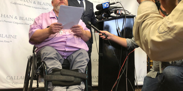 Attorney Daniel J. Callahan, right, looks at his client, Geoffrey Johnson, during a news conference announcing a lawsuit filed against lawyer Michael Avenatti in Santa Ana, Calif., Thursday, June 13, 2019. Johnson says that Avenatti, his former lawyer, received a $4 million settlement check from Los Angeles County over injuries he suffered in sheriff department custody and failed to pay Johnson his share or tell him the check was in. (AP Photo/Amy Taxin)