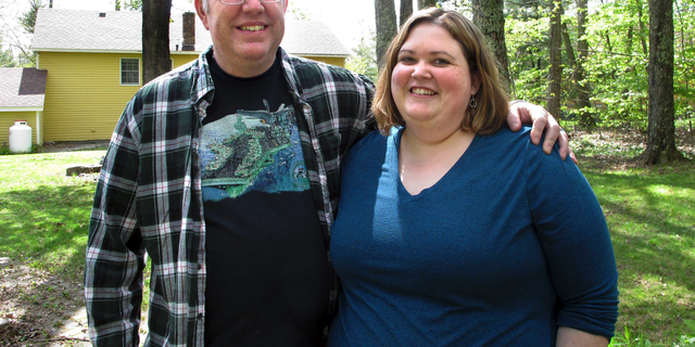 In this May 15, 2019, photo, Jonathan and Beth Dow stand in their backyard in Bennington, Vt. The couple recently moved to Vermont from Colorado through a Vermont program to attract new residents. (AP Photo/Lisa Rathke)