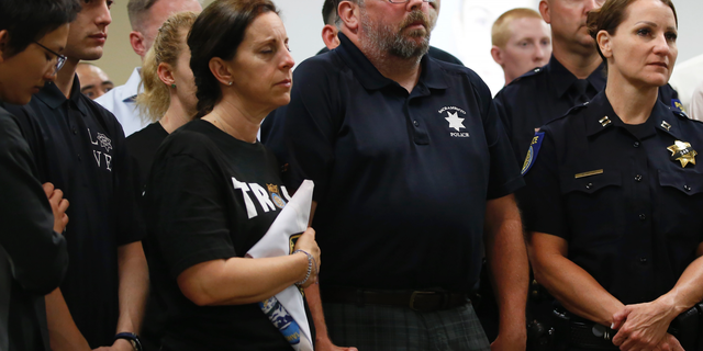 With their eyes closed, Kelly and Denis O'Sullivan, the parents of slain Sacramento Police officer Tara O'Sullivan, hold hands during a news conference in Sacramento, Calif., Tuesday, June 25, 2019. (AP Photo/Rich Pedroncelli)