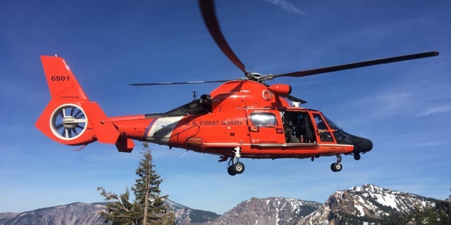 An MH-65 Dolphin helicopter landing at a Crater Lake parking area to transfer the injured man to AirLink Critical Care Transport on Monday. (U.S. Coast Guard photo courtesy of Sector North Bend)