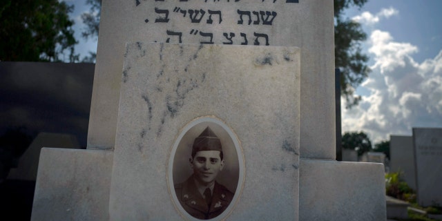 CORRECTS THE NAME OF THE WAR - The portrait of a young Cuban soldier who died fighting in The Korean War decorates his tomb at a Jewish cemetery in Guanabacoa, eastern Havana, Cuba, June 7, 2019. Many Jewish families left the country after the 1959 revolution, leaving behind their dead in accordance with Jewish custom that prohibits bodies from being exhumed unless they are taken to Israel. (AP Photo/Ramon Espinosa)