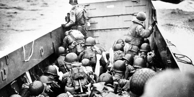 Troops crouch inside a LCVP landing craft, just before landing on Omaha Beach on D-Day, 6 June 1944. Photograph from the U.S. Coast Guard Collection in the U.S. National Archives.