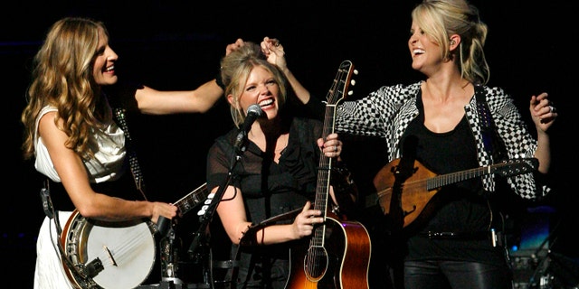 Emily Robison, left, and Martie Maguire, right, adjust Natalie Maines' hair as the Dixie Chicks perform at the new Nokia Theatre in Los Angeles.