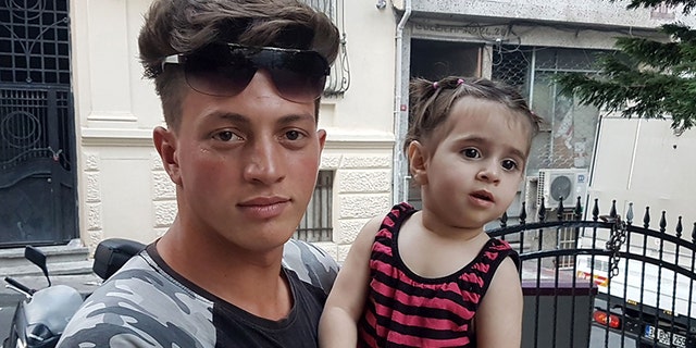 Algerian citizen Fawzi Zabaat (L), 17, poses with Syrian toddler Doha Muhammed he caught as she was falling from the second floor at Fatih district in Istanbul on June 27, 2019. (Photo by STR / DHA / AFP) / Turkey OUT (Photo credit should read STR/AFP/Getty Images)