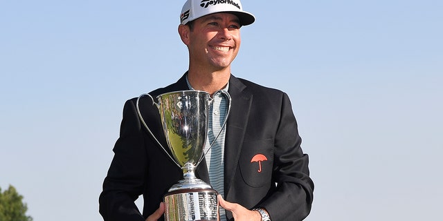 Chez Reavie, winner of the Travelers Championship golf tournament poses with the trophy, Sunday, June 23, 2019, in Cromwell, Conn. (AP Photo/Jessica Hill)