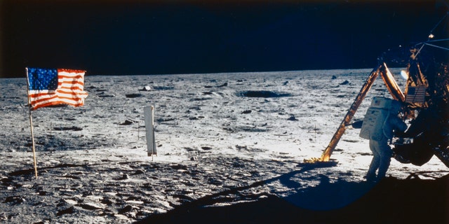 Neil Armstrong is shown next to the lunar module. One can also see the United States flag and the solar wind experience practiced in all Apollo missions.