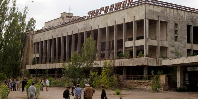 Visitors look in the abandoned city of Pripyat, near the Chernobyl nuclear power plant, in June 2019. Tourist companies in the area have reported a sharp increase in the number of bookings since HBO's "Chernobyl" debuted.