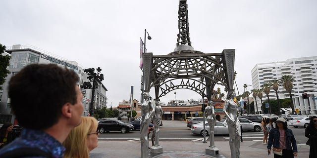 Tourists stop to look at the "Ladies of Hollywood Gazebo" on the Hollywood Walk of Fame in Hollywood, California, June 18, 2019. - A statue of Marilyn Monroe which is normally perched atop the gazebo's Eiffel Tower-shaped structure was stolen on June 16. (Getty Images)