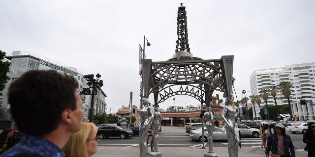Tourists stop to look at the "Ladies of Hollywood Gazebo" on the Hollywood Walk of Fame in Hollywood, California, June 18, 2019. - A statue of Marilyn Monroe which is normally perched atop the gazebo's Eiffel Tower-shaped structure was stolen on June 16. (Getty Images)
