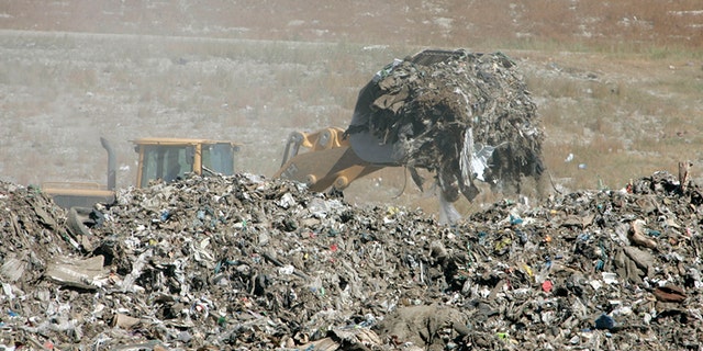 A front loader starts to move several tons of trash so it can be searched by hand for Lori Hacking's body at the Salt Lake City Dump Sept. 14, 2004, in Salt Lake City, Utah. (Photo by George Frey/Getty Images)
