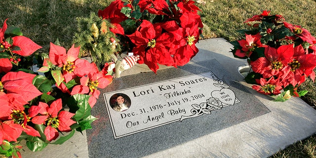 Flowers and a Christmas decoration surround the grave of Lori Hacking in the Orem City Cemetery, minus the Hacking family name Dec. 6, 2004, in Orem, Utah. (Photo by George Frey/Getty Images)