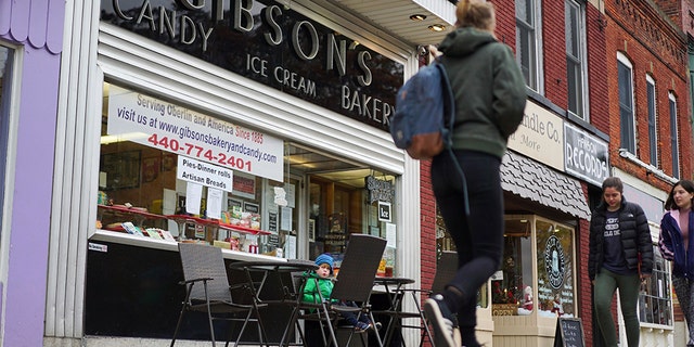 In this Nov. 22, 2017 file photo, pedestrians pass the storefront of Gibson's Food Mart &amp; Bakery in Oberlin, Ohio. (AP Photo/Dake Kang)