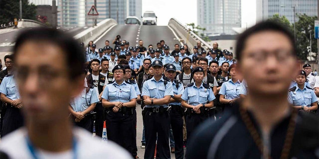Police arriving to negotiate with protesters to clear a road in Hong Kong.