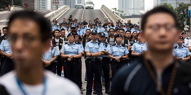Police arriving to negotiate with protesters to clear a road in Hong Kong.