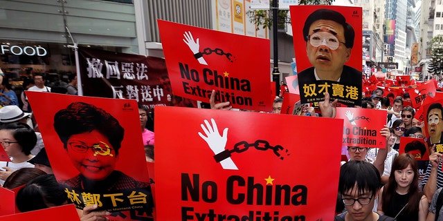 Demonstrators hold signs during a protest to demand authorities scrap a proposed extradition bill with China, in Hong Kong, China June 9, 2019.