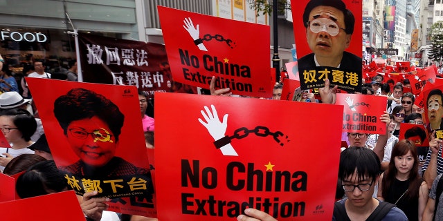 Demonstrators hold signs during a protest to demand authorities scrap a proposed extradition bill with China, in Hong Kong, China June 9, 2019.