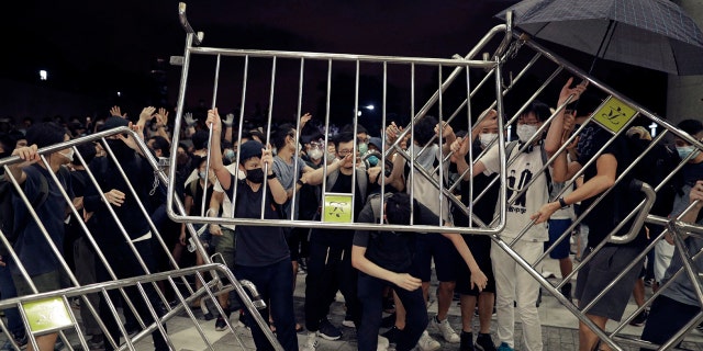 Protesters use barriers against the proposed amendments to the extradition law at the Legislative Council in Hong Kong during the early hours of Monday, June 10, 2019.