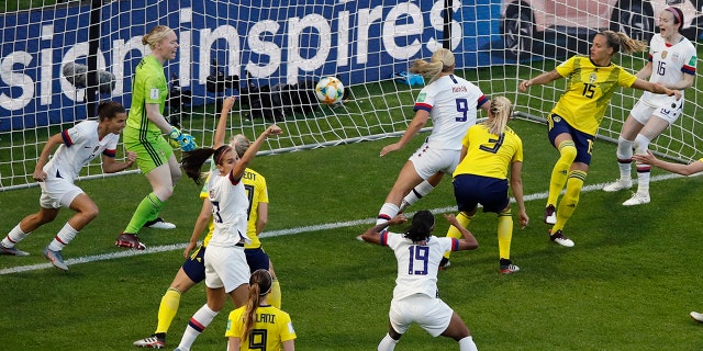 Lindsey Horan (9) wheels away after scoring the opening goal as her teammates celebrate. (AP Photo/Christophe Ena)