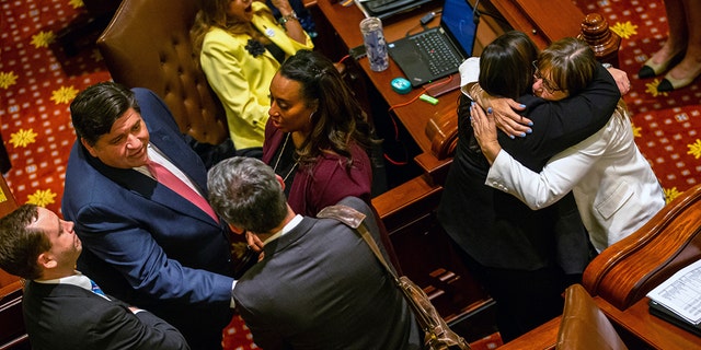 Illinois Gov. J.B. Pritzker, left, and Sen. Melinda Bush, right, D-Grayslake, celebrate passage by Senate of the Reproductive Health Act Friday. The bill establishes a woman's "fundamental right" to an abortion. (The State Journal-Register via AP)